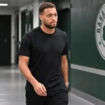 Cyriel Dessers loopt na een Europese wedstrijd door een stadiongang met een Panathinaikos-embleem op de wand.
