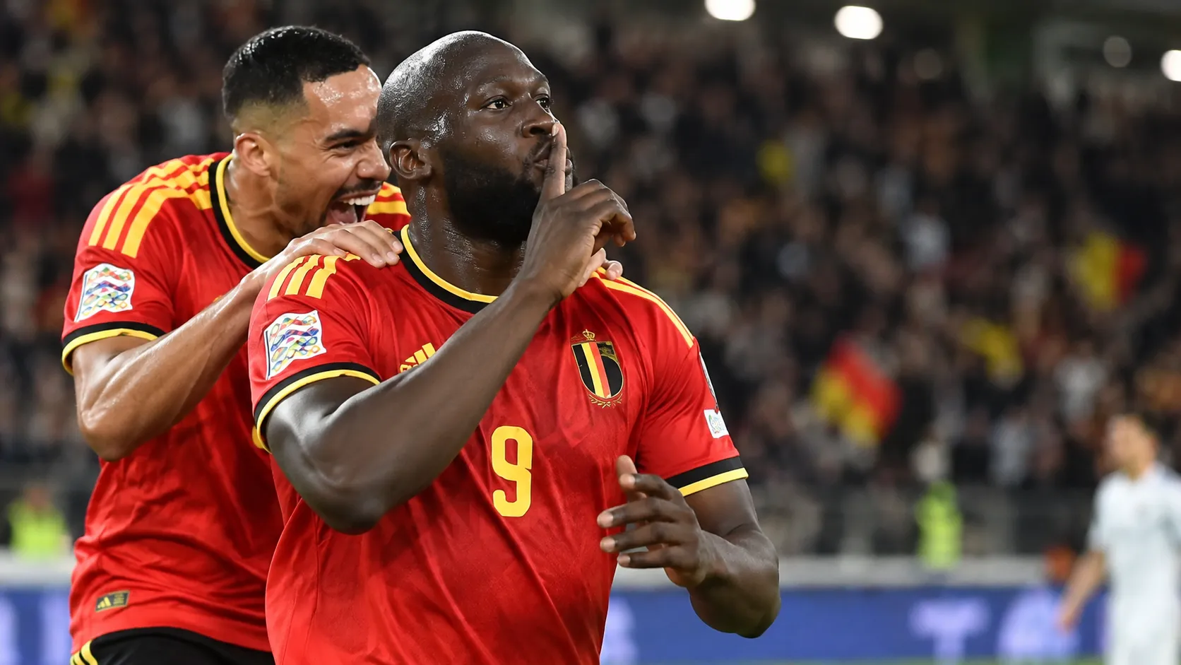 Romelu Lukaku in het rode tenue van België viert op het veld naast een ploegmaat.
