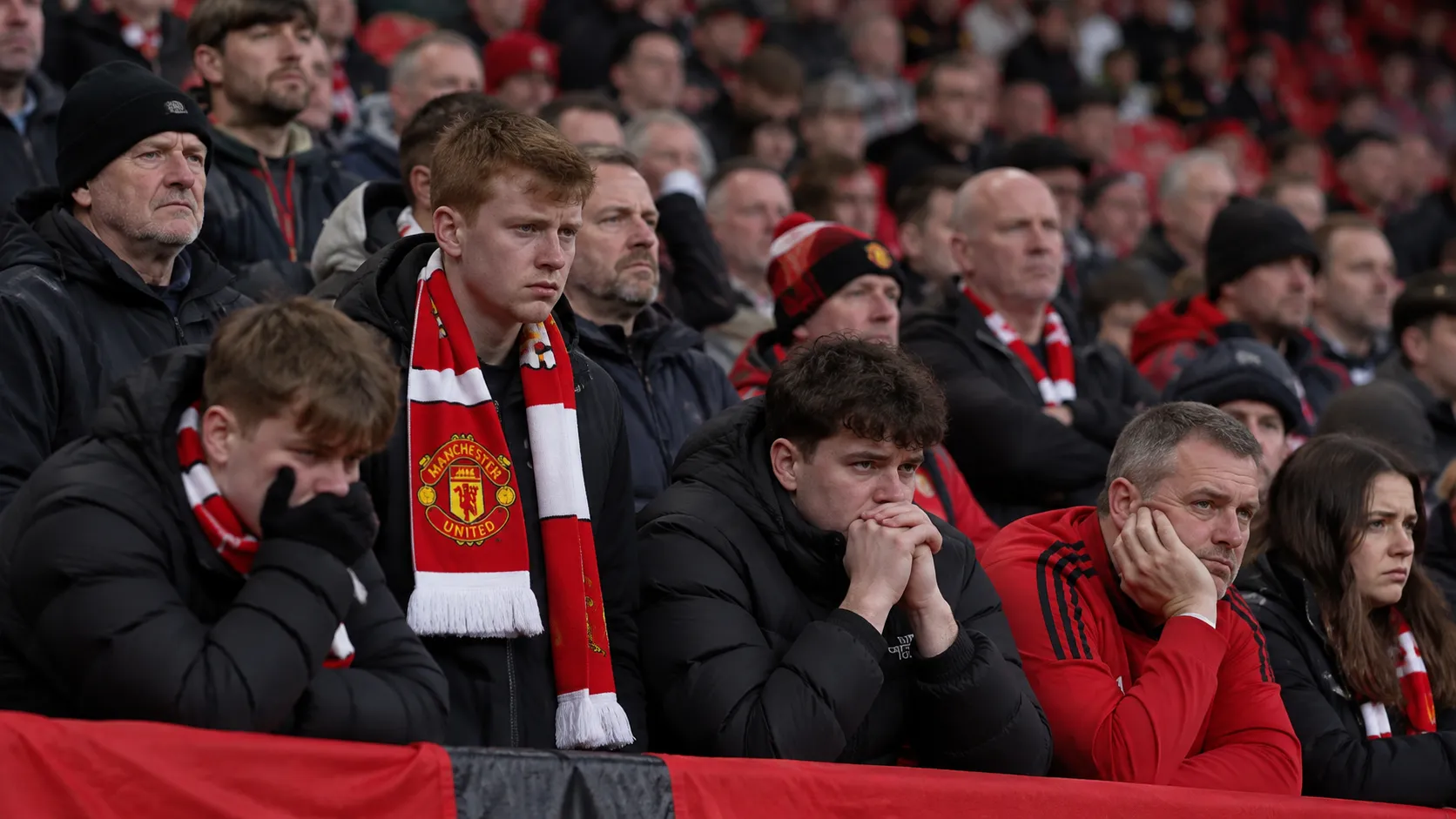 Teleurgestelde Manchester United-supporters op de tribune van Old Trafford na een nederlaag.