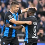 Twee spelers van Club Brugge vieren samen een actie tijdens een wedstrijd.