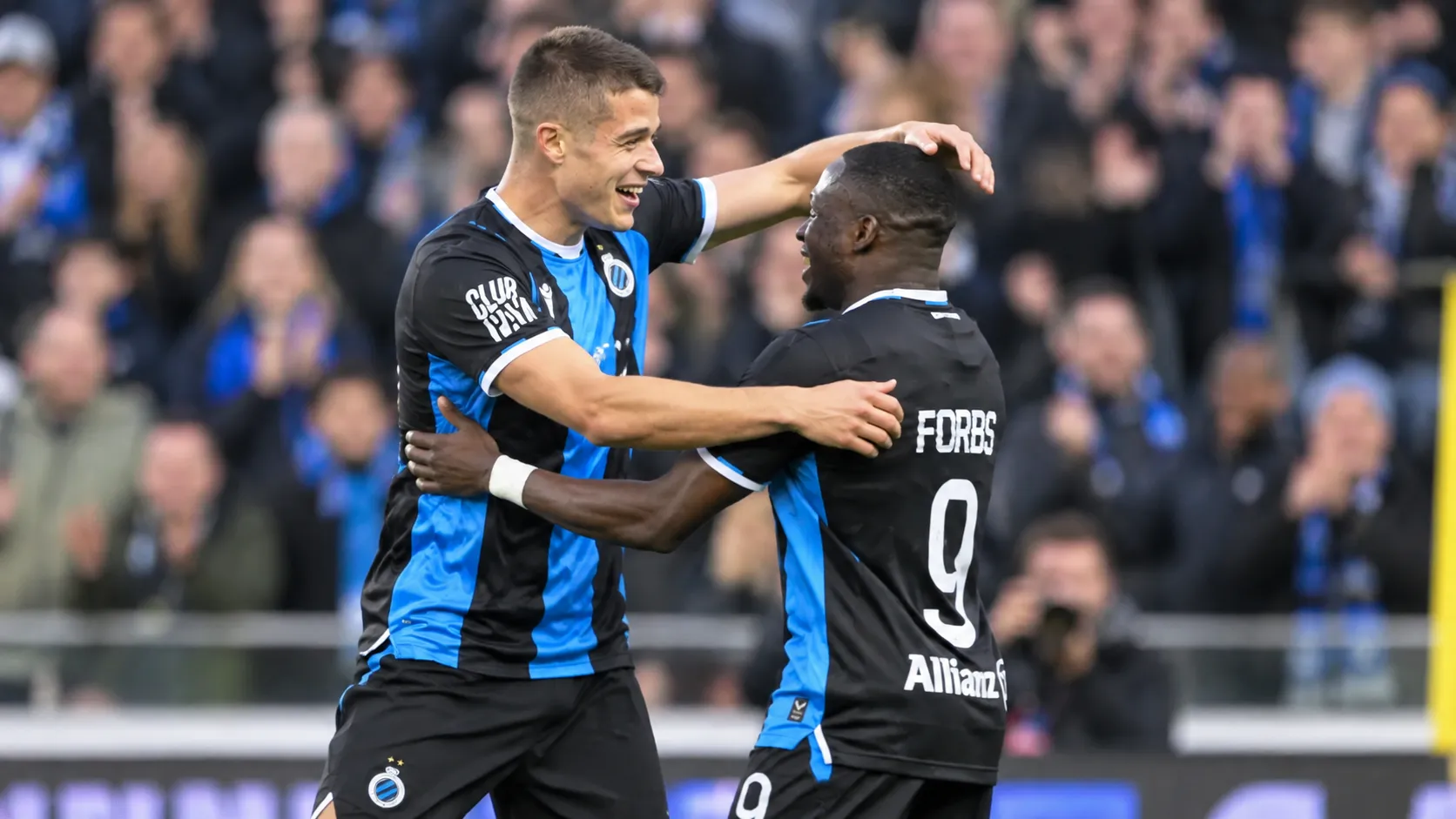 Twee spelers van Club Brugge vieren samen een actie tijdens een wedstrijd.