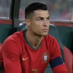 Cristiano Ronaldo zit op de spelersbank van Portugal in zijn nationale wedstrijdshirt.