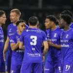 Een groep spelers van Patro Eisden verzamelt zich tijdens een wedstrijd in de Challenger Pro League.