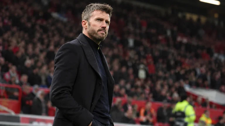 Michael Carrick staat langs de zijlijn in een voetbalstadion.