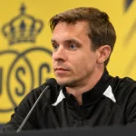 Een Union-coach in een zwarte trainingsjas tijdens een persmoment.