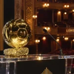 De Ballon d’Or-trofee op een podium in een verlichte galazaal.