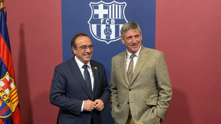 Twee mannen in pak bij een clubachtergrond van FC Barcelona.