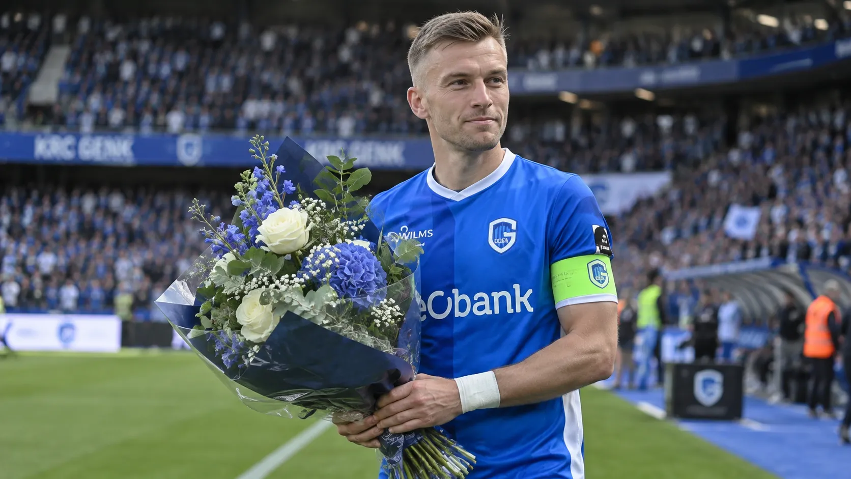 Bryan Heynen van KRC Genk ontvangt voor de aftrap bloemen op het veld.