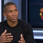 Ashley Young spreekt in een televisiestudio met een Manchester United-embleem op een analysescreen.
