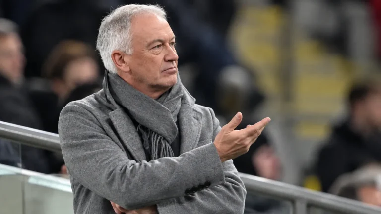 Marc Degryse gebaart op de tribune van een stadion.