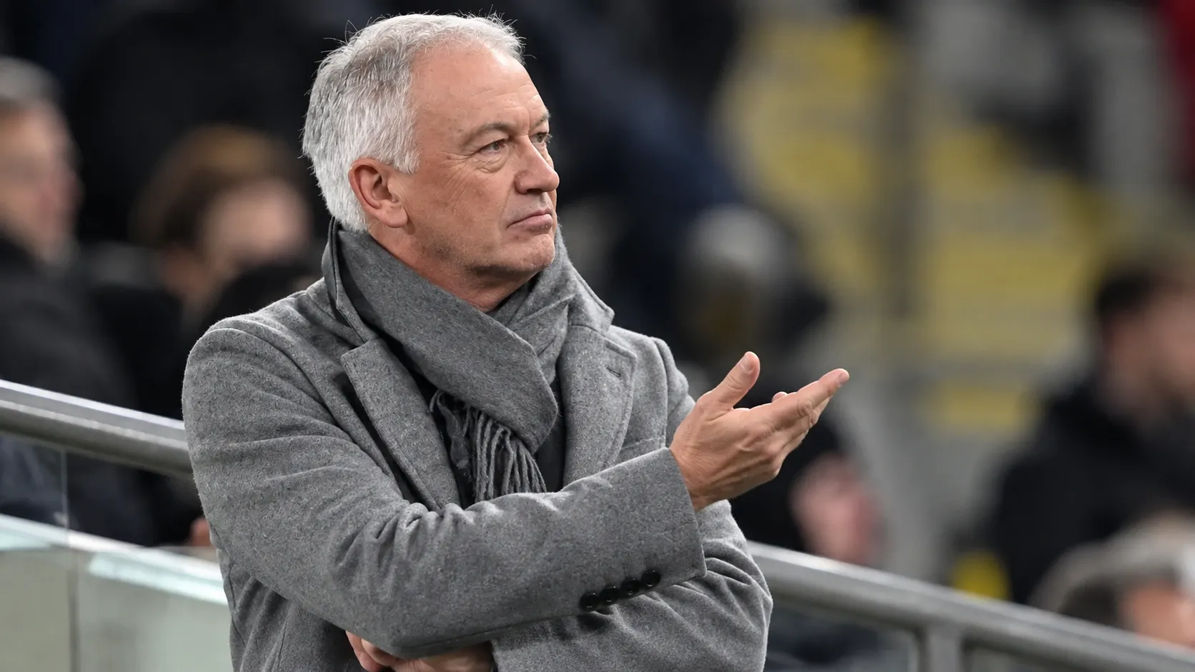 Marc Degryse gebaart op de tribune van een stadion.