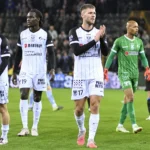 Spelers en een scheidsrechter op het veld na het laatste fluitsignaal.