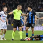 Een scheidsrechter staat tussen spelers na het laatste fluitsignaal van Club Brugge tegen STVV.