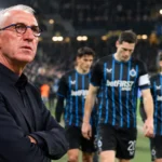 Franky Van der Elst staat langs het veld terwijl spelers van Club Brugge op de achtergrond passeren.