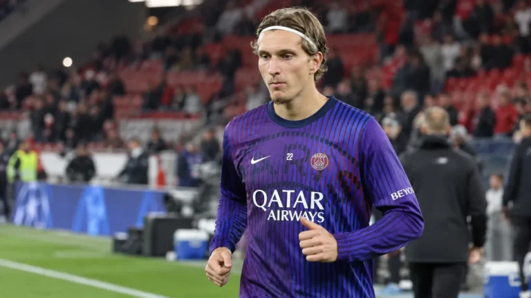 Een PSG-speler in een paars trainingsshirt op het veld voor een wedstrijd.