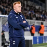 Will Still in een donkerblauw trainingspak van Auxerre in de technische zone na een wedstrijd.