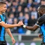 Twee spelers van Club Brugge vieren samen op het veld.