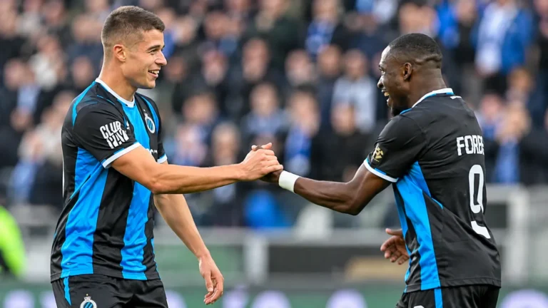 Twee spelers van Club Brugge vieren samen op het veld.