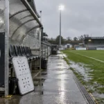Lege technische zone van FC Knokke langs een nat voetbalveld.