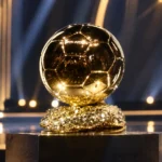 De Ballon d'Or-trofee op een verlicht podium in een theaterzaal.