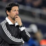 Een coach van Anderlecht volgt geconcentreerd de wedstrijd vanaf de zijlijn.