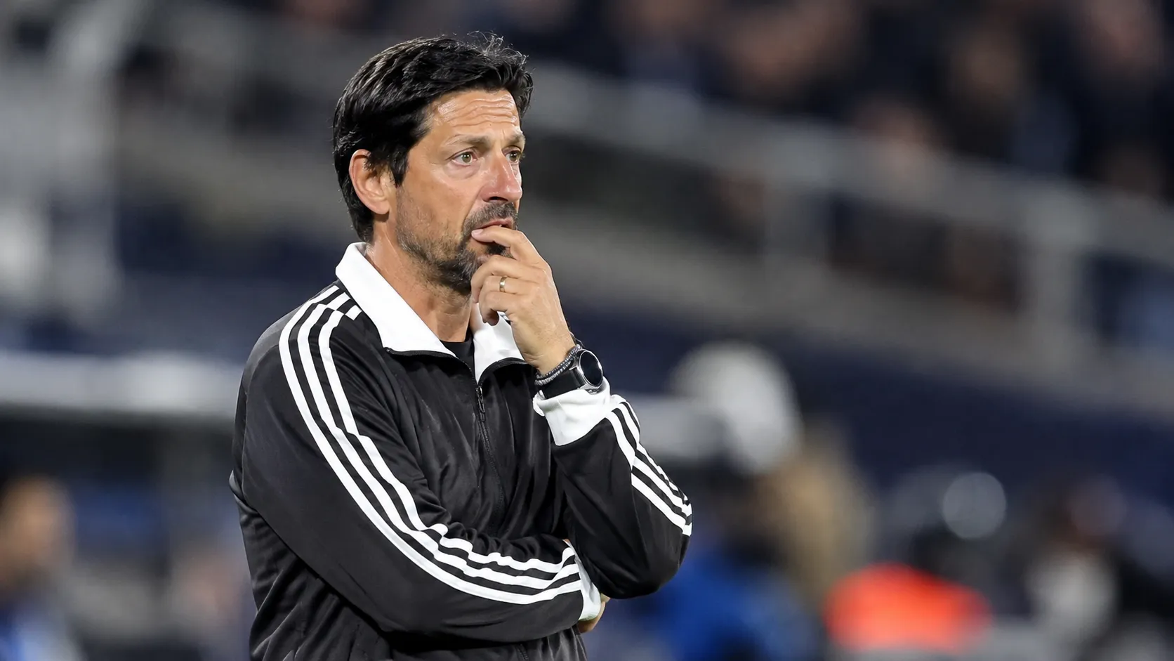 Een coach van Anderlecht volgt geconcentreerd de wedstrijd vanaf de zijlijn.