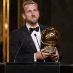 Harry Kane houdt de Ballon d'Or-trofee vast op het podium tijdens de prijsuitreiking.