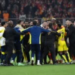 Spelers en stafleden proberen een opstootje op het veld te bedaren.