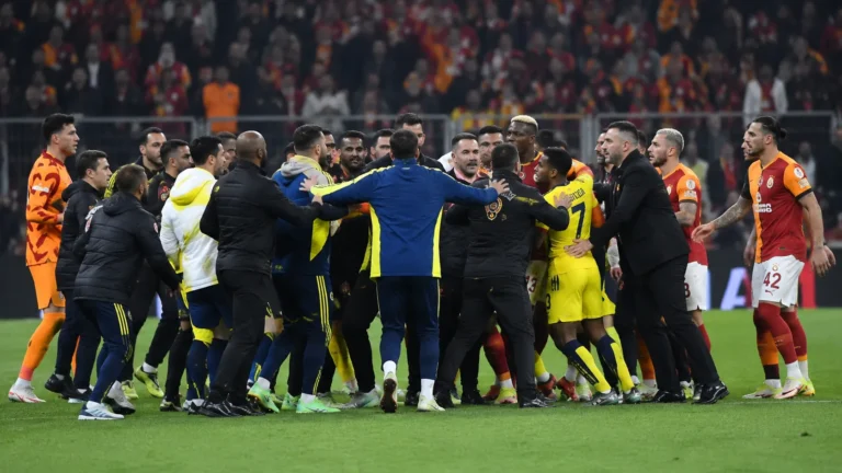 Spelers en stafleden proberen een opstootje op het veld te bedaren.