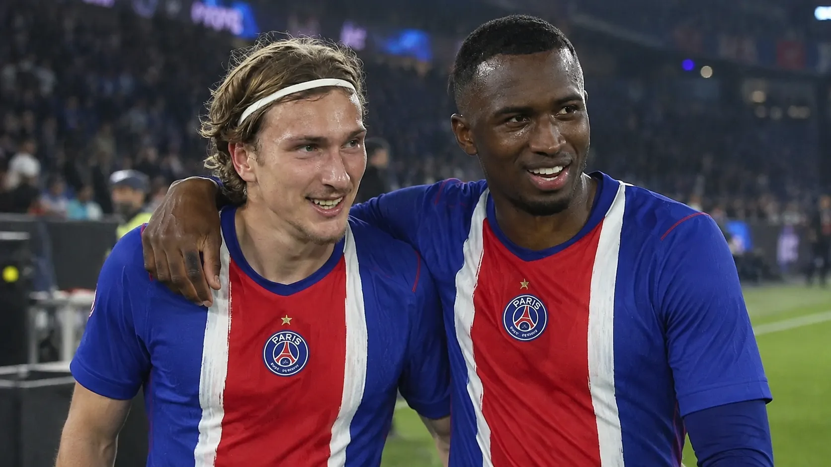Twee PSG-spelers wandelen samen op het veld na een wedstrijd in Parijs.