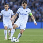 Twee KRC Genk-spelers in witte tenues tijdens een oefenwedstrijd.