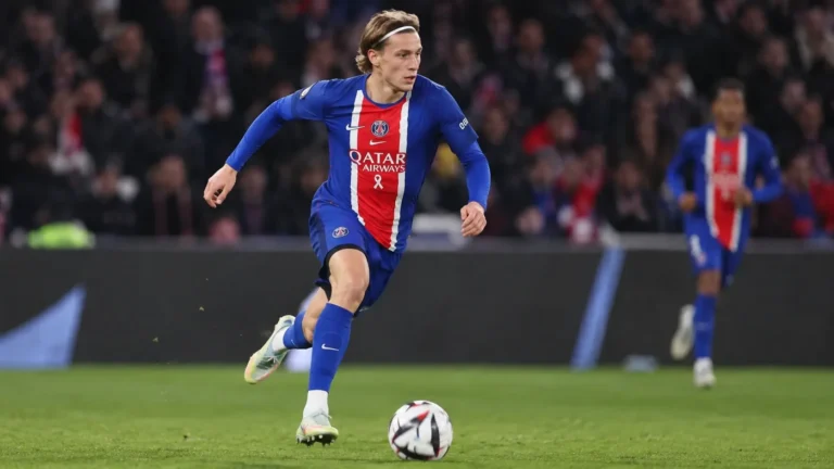 Mika Godts in blauw-rood clubtenue tijdens een snelle wedstrijdactie.