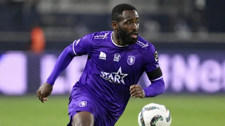 Arnold Vula in paars wedstrijdtenue tijdens een aanvallende actie op het voetbalveld.