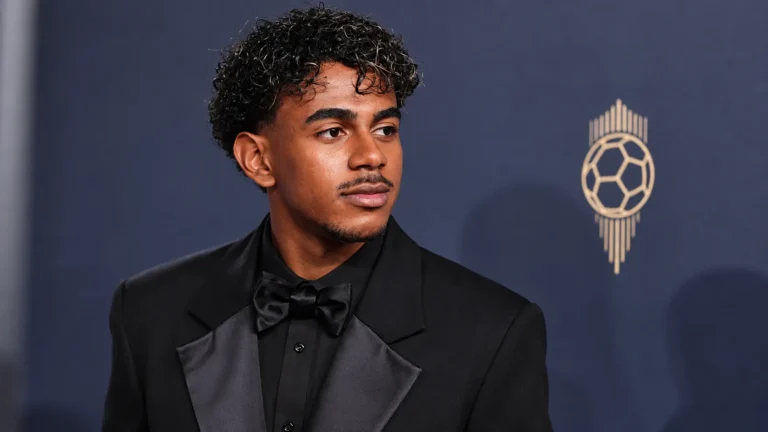 Lamine Yamal in zwart avondpak bij een perswand van de Ballon d'Or-ceremonie.