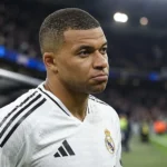 Kylian Mbappé in het witte shirt van Real Madrid langs de rand van het veld.