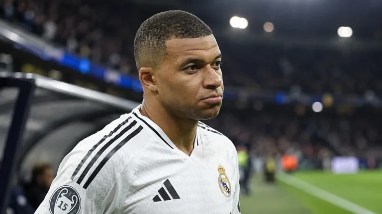 Kylian Mbappé in het witte shirt van Real Madrid langs de rand van het veld.
