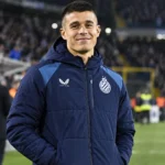 Nicolo Tresoldi in een Club Brugge-jas langs de zijlijn van een gevuld stadion.