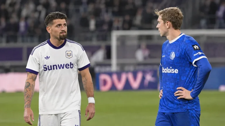 Twee voetballers van de tegenstanders praten na afloop op het veld.