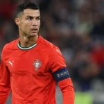 Cristiano Ronaldo in het rode tenue van Portugal op het veld in een stadion.