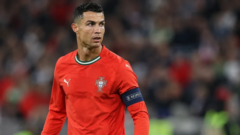 Cristiano Ronaldo in het rode tenue van Portugal op het veld in een stadion.