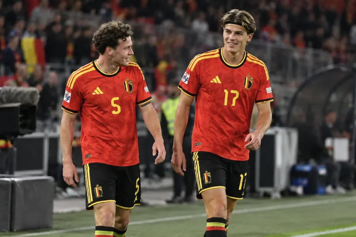 Twee Belgische internationals in rode shirts staan na een spelmoment aan de zijlijn.