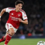 Een Arsenal-speler in het thuistenue jaagt tijdens een bekerwedstrijd op de bal.