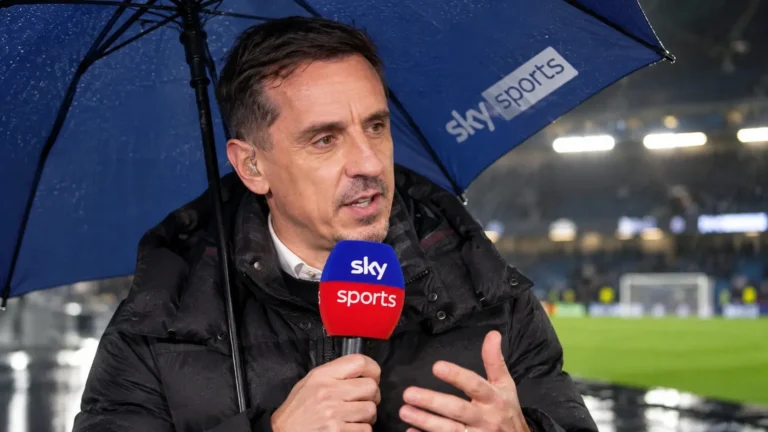 Gary Neville spreekt onder een paraplu in een Sky Sports-microfoon.