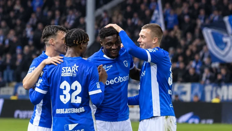 Een groep spelers van KRC Genk viert samen op het veld tijdens een wedstrijd.