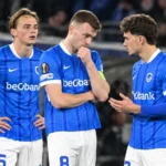 Drie spelers van KRC Genk tijdens een rustig moment langs het veld.