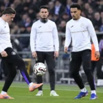 Een groep Anderlecht-spelers warmt op langs de zijlijn van een voetbalstadion.