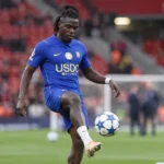 Roméo Lavia warmt op in het blauwe Chelsea-tenue op het veld van Anfield.