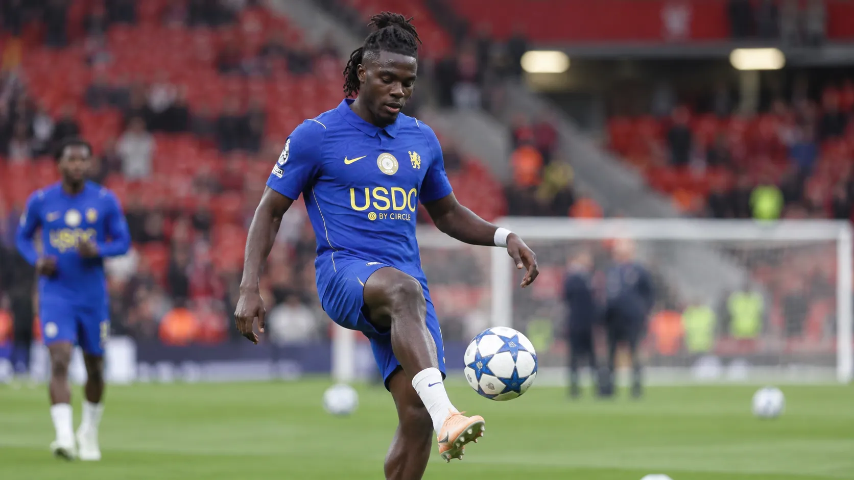 Roméo Lavia warmt op in het blauwe Chelsea-tenue op het veld van Anfield.
