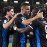 Een groep spelers van Club Brugge viert samen op het veld.