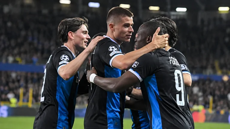 Een groep spelers van Club Brugge viert samen op het veld.